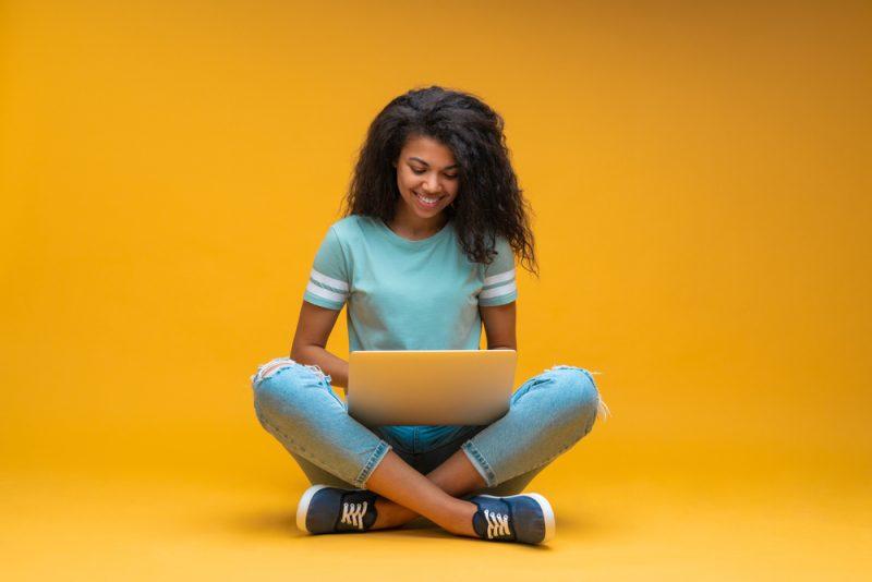 Jeune entrepreneuse utilisant son ordinateur pour apprendre comment créer un logo avec l’IA