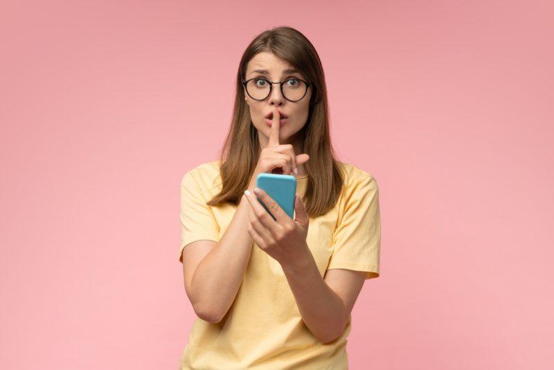 Jeune entrepreneuse avec un smartphone, illustrant une stratégie TikTok et Instagram 2026 basée sur des astuces réseaux sociaux.