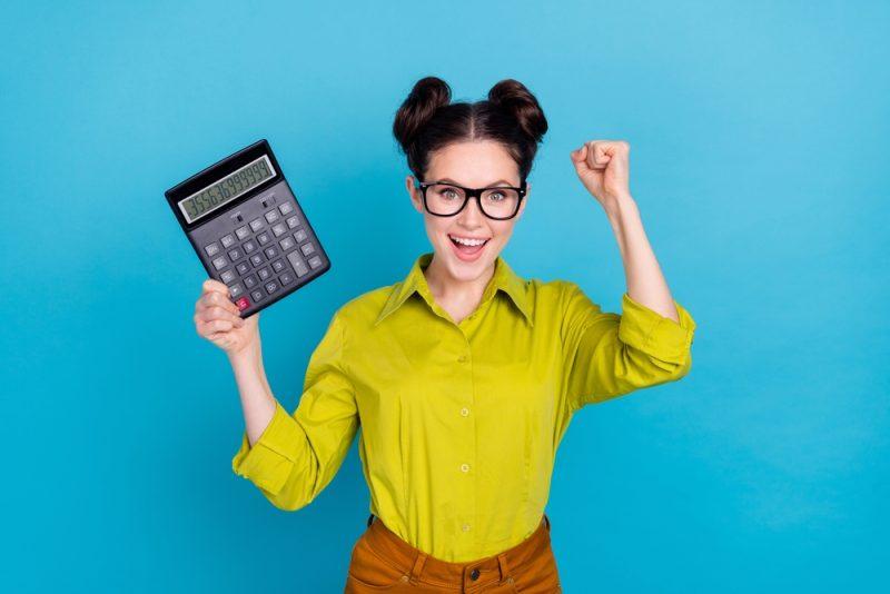 Entrepreneuse tenant une calculatrice illustrant une formation comptabilité pour comprendre les bases de la comptabilité