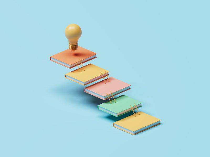 Illustration de livres formant un escalier vers une ampoule pour représenter la formation de formateur et la progression vers le métier de formateur